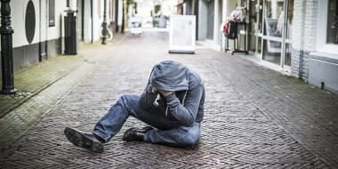 Man zittend op straat