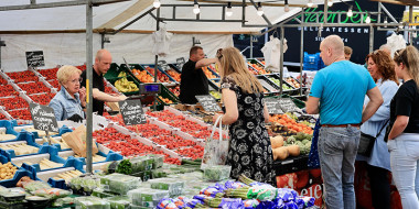 Klanten op de markt bij de groente- en fruitkraam