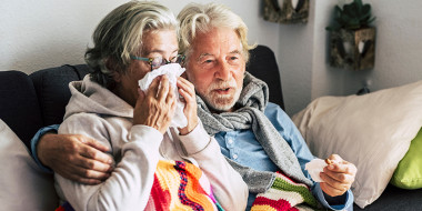 Twee ouderen met zakdoeken op een bank